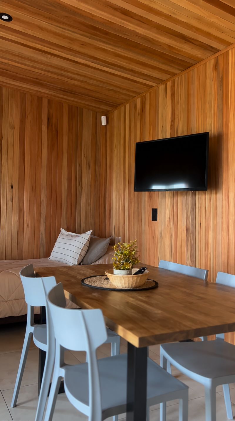 Interior con mesa de madera, cama y tele